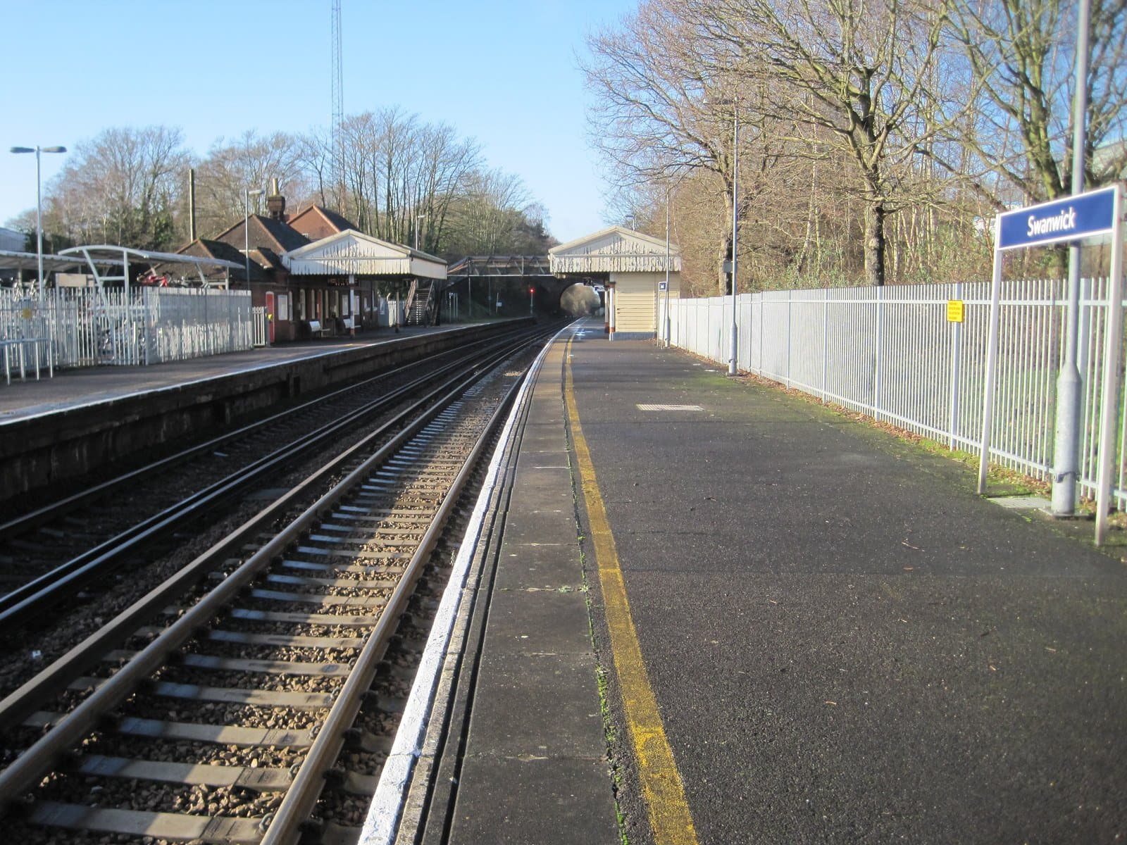 Platforms and station buildings at Swanwick railway station, Hampshire, under a clear winter sky
